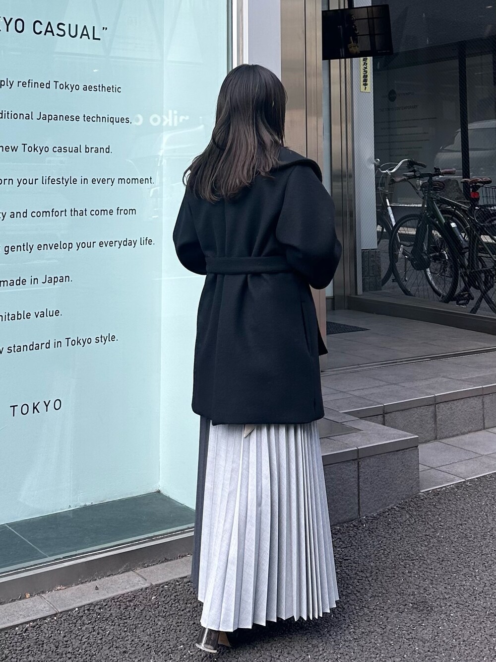 ブラック系のチェスターコート、グレー系のスカートを着用したレディースの冬コーディネートの4枚目の写真