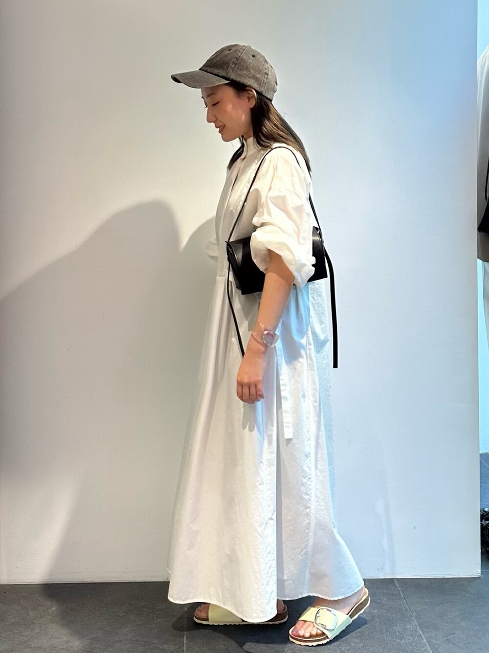 ホワイト系のシャツワンピースを着用したレディースの夏コーディネートの2枚目の写真