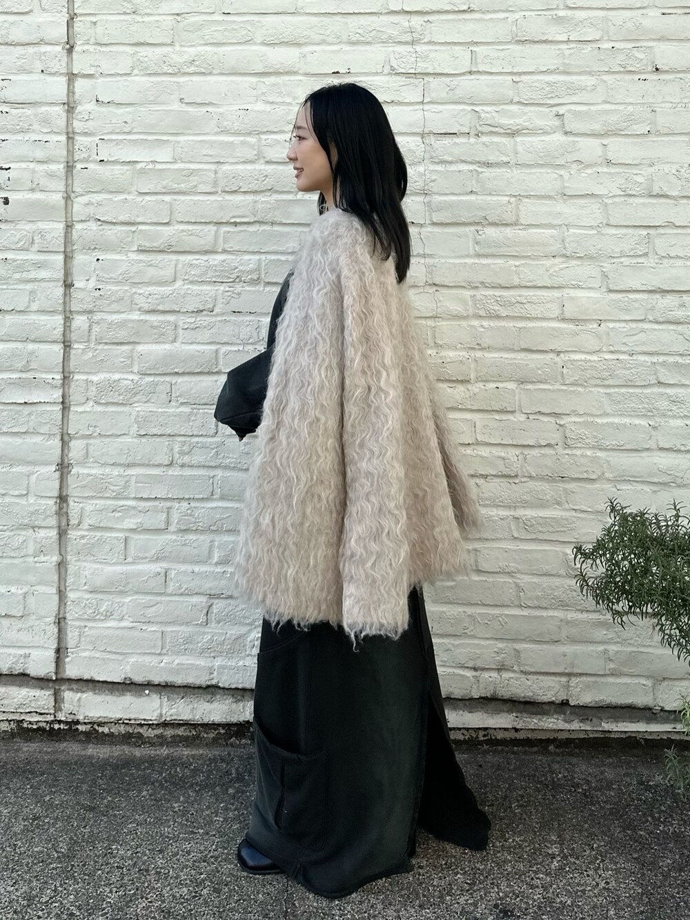 ベージュ系のカーディガン/ボレロを着用したレディースの冬コーディネートの2枚目の写真