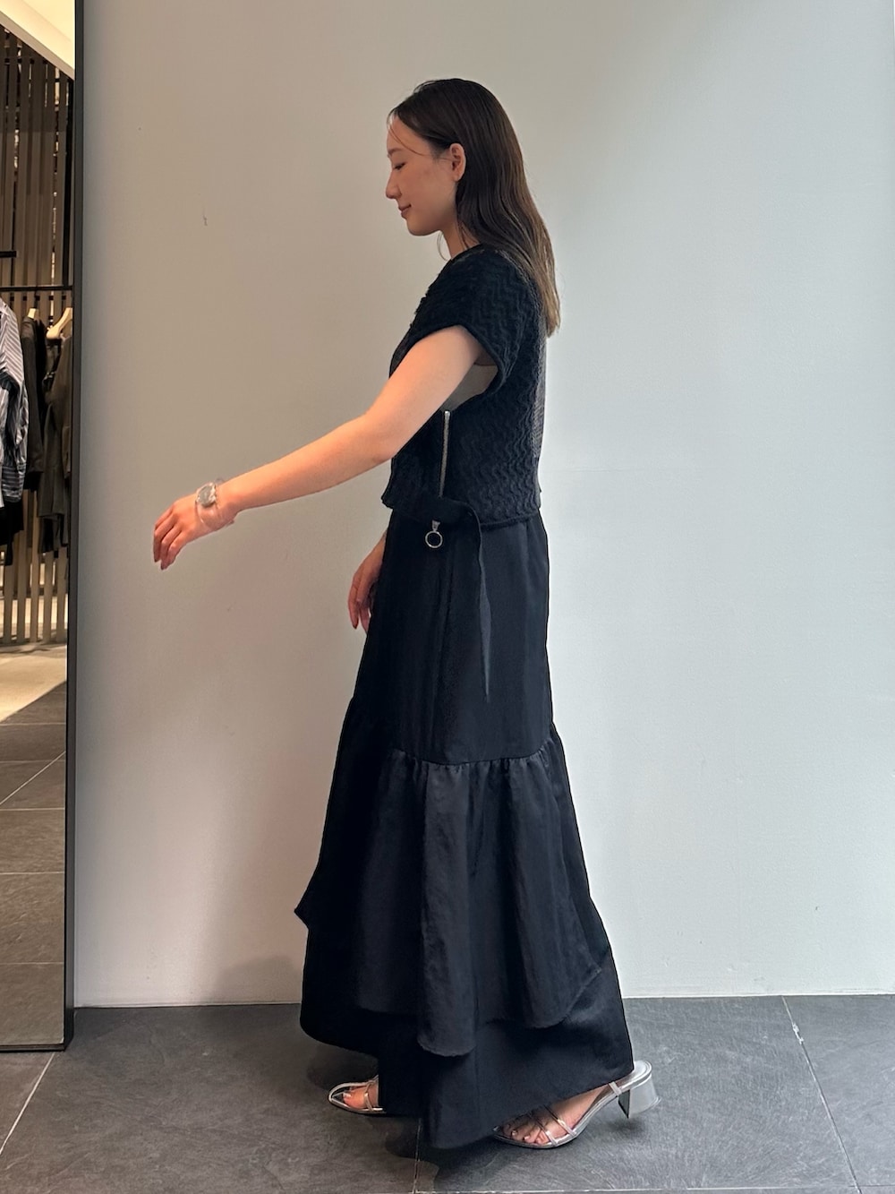 ブラック系のスカート、ブラウン系のベストを着用したレディースの秋コーディネートの4枚目の写真