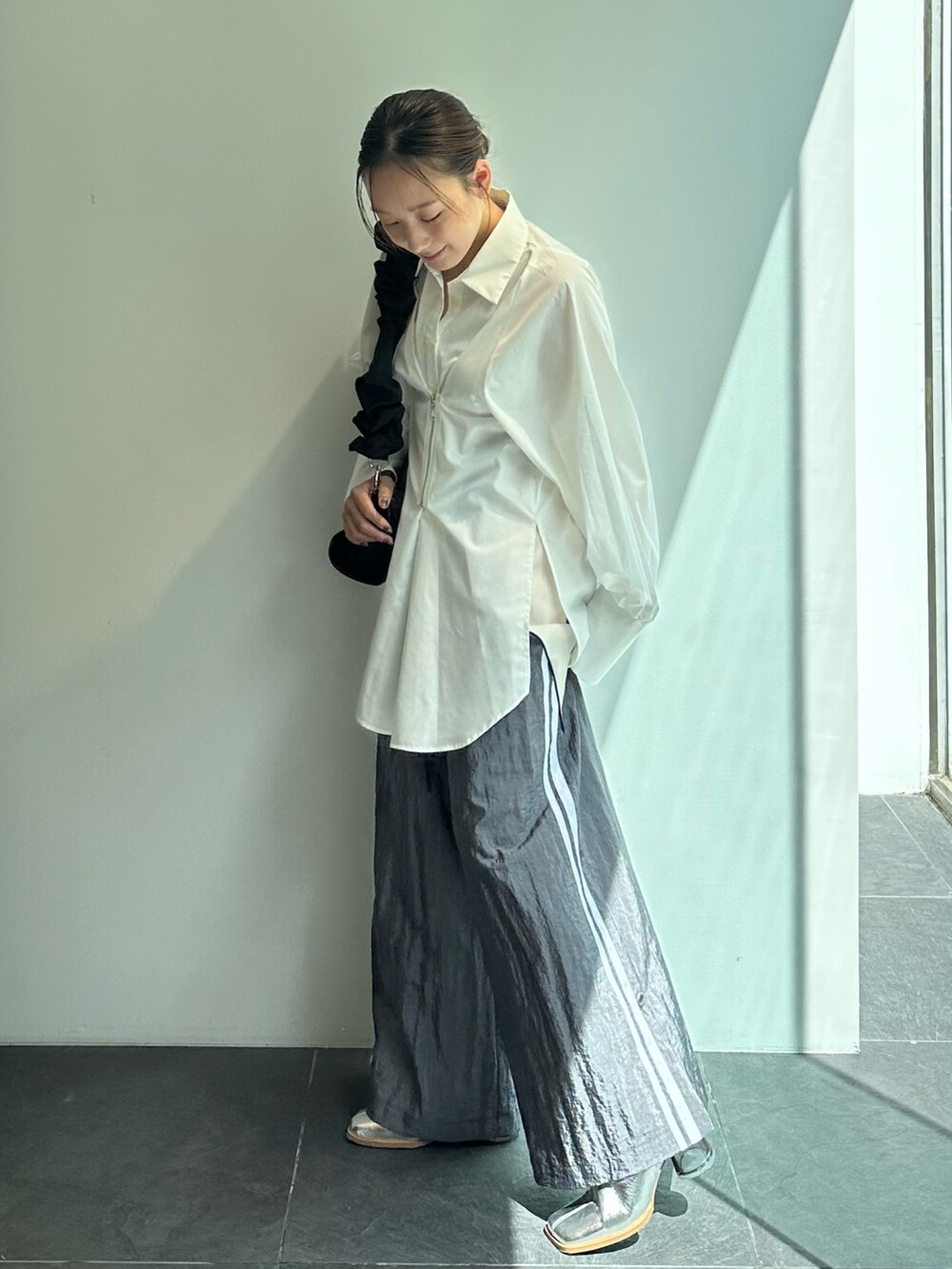 ブラック系のショルダーバッグ、ホワイト系のシャツ/ブラウス、グレー系のその他パンツを着用したレディースの秋コーディネートの2枚目の写真