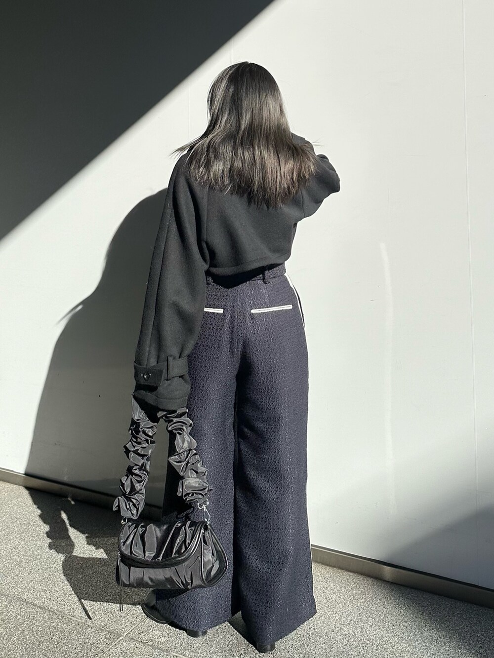 ブルー系のその他パンツ、ブラック系のステンカラーコートを着用したレディースの冬コーディネートの3枚目の写真