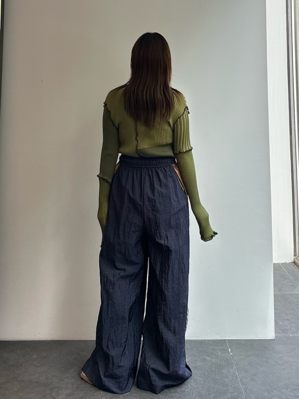 グリーン系のニット/セーター、ブルー系のその他パンツを着用したレディースの秋コーディネートの5枚目の写真