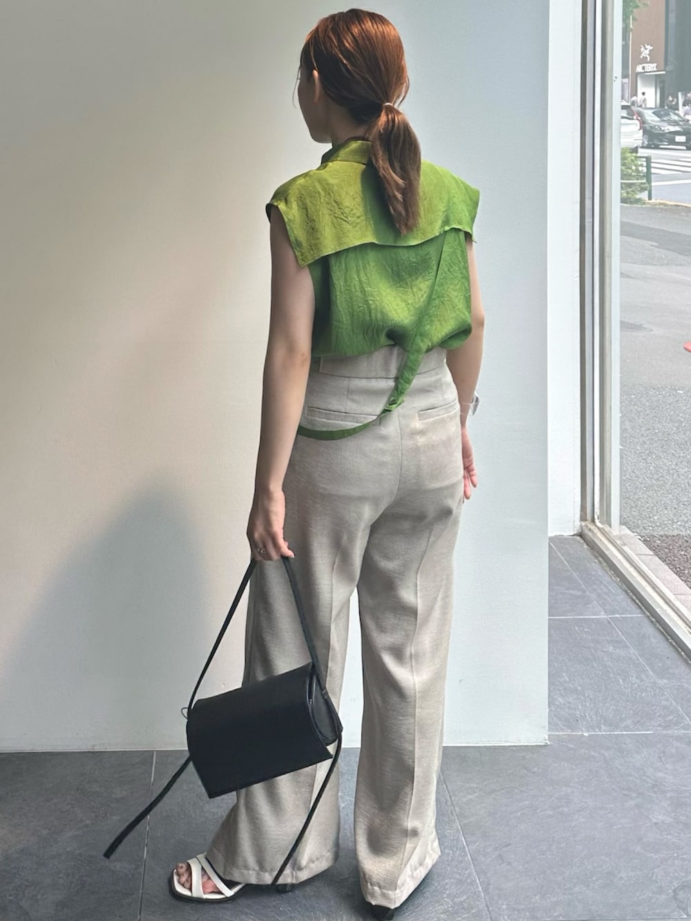 グリーン系のシャツ/ブラウス、ベージュ系のスラックスを着用したレディースの夏コーディネートの3枚目の写真