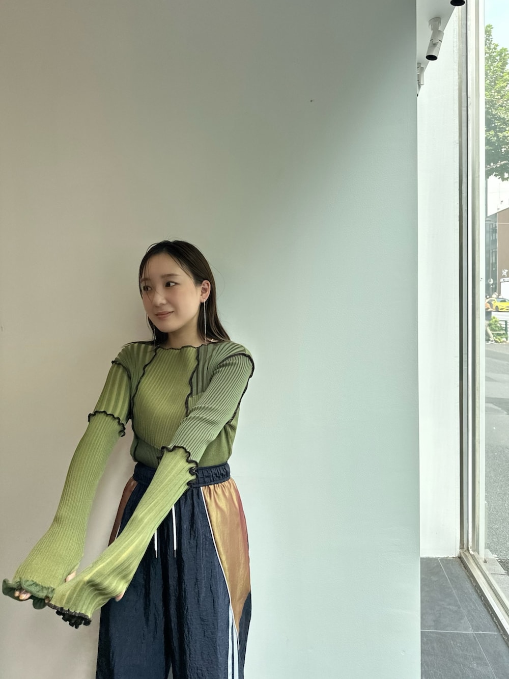 グリーン系のニット/セーター、ブルー系のその他パンツを着用したレディースの秋コーディネートの6枚目の写真