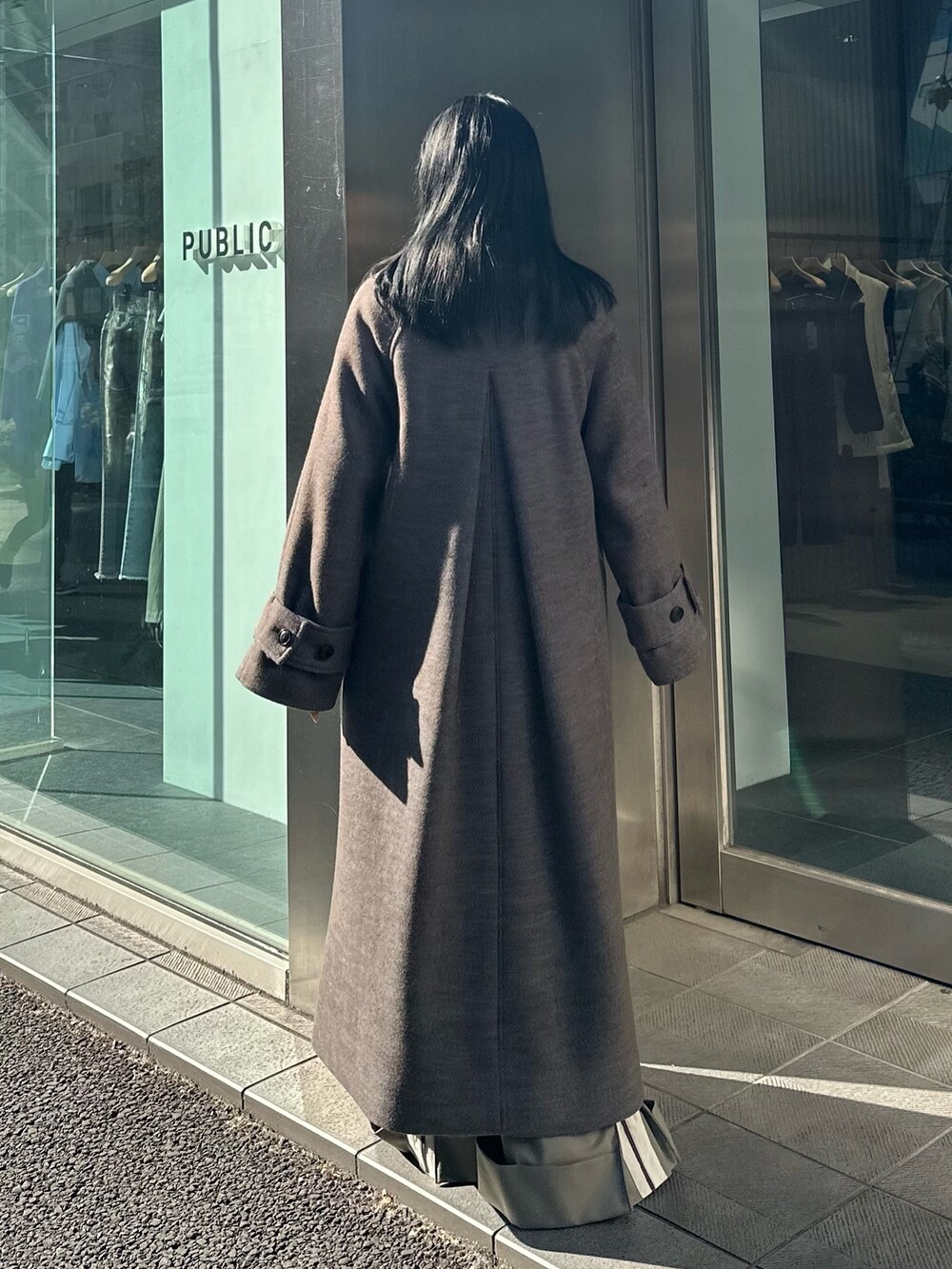 ブルー系のステンカラーコートを着用したレディースの冬コーディネートの3枚目の写真