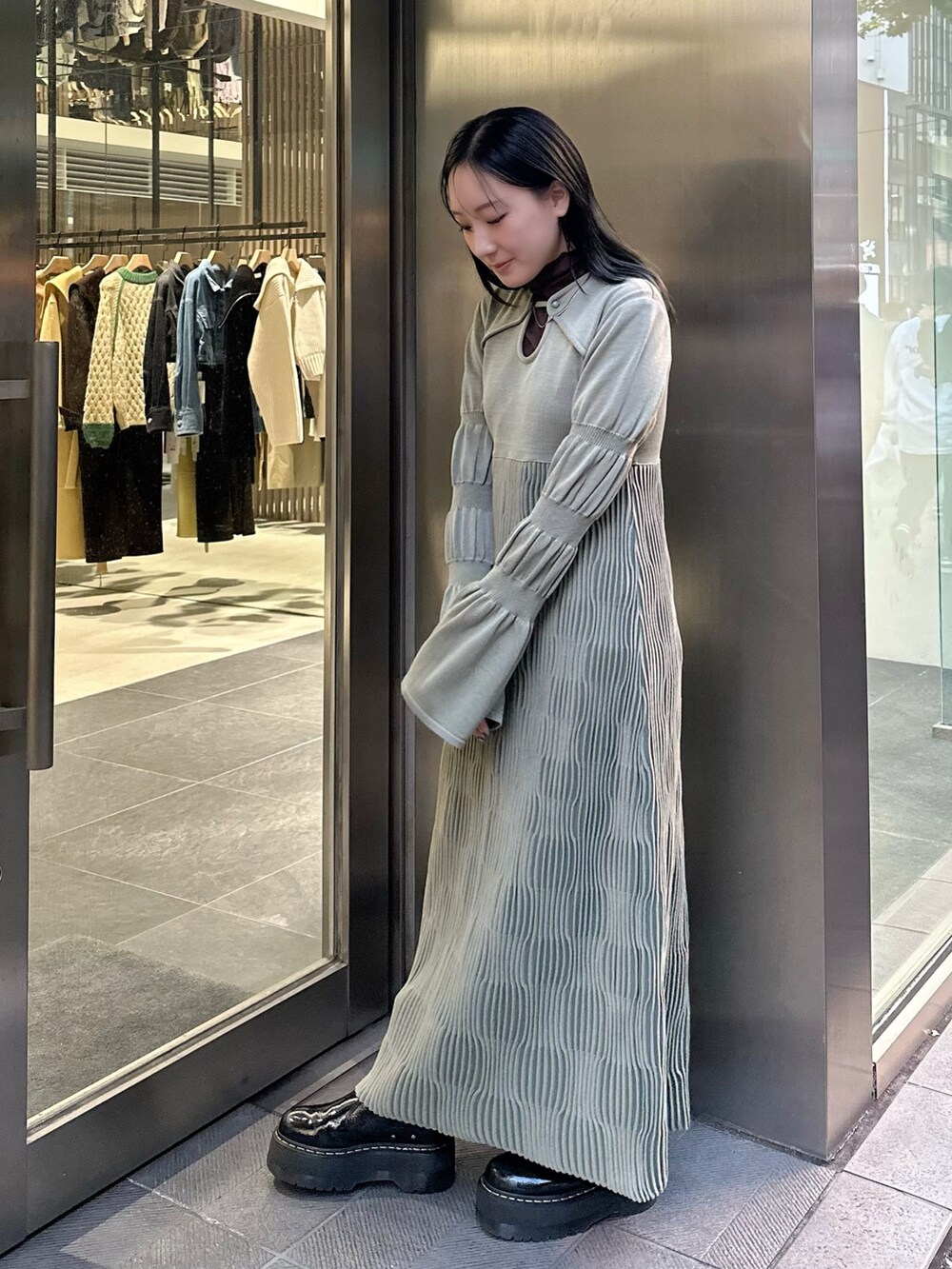 グリーン系のワンピースを着用したレディースの秋コーディネートの2枚目の写真