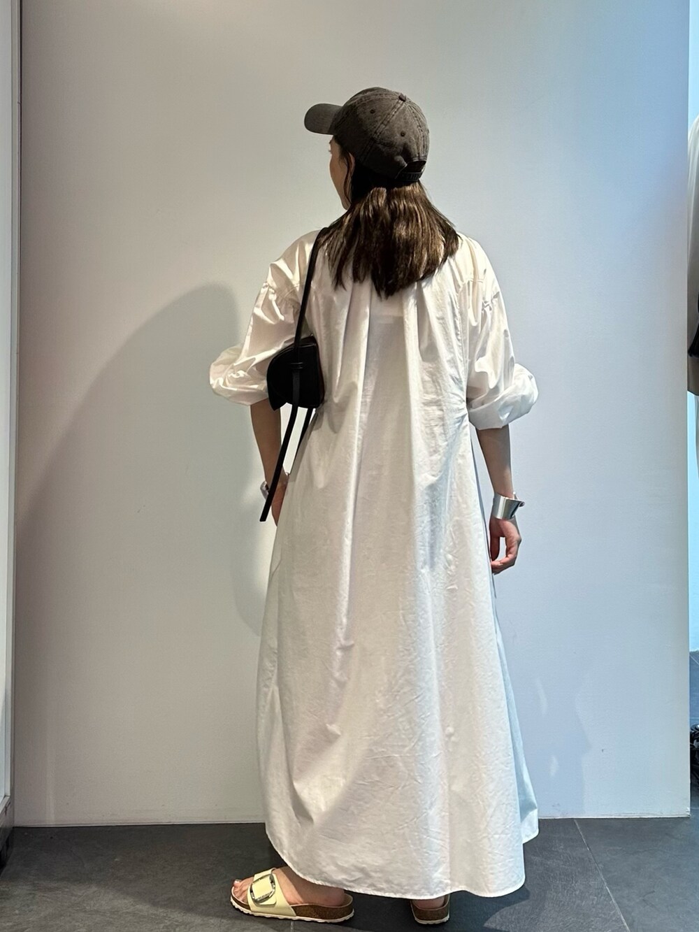 ホワイト系のシャツワンピースを着用したレディースの夏コーディネートの4枚目の写真