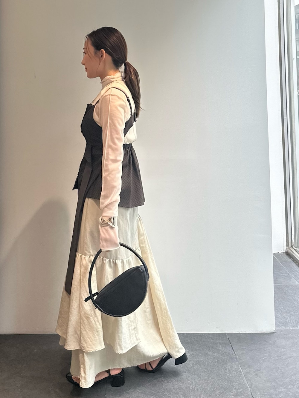 ホワイト系のTシャツ/カットソー、ブラウン系のキャミソール、ベージュ系のスカートを着用したレディースの秋コーディネートの3枚目の写真