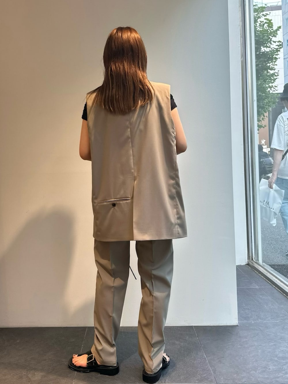 グレー系のベスト、グレー系のスラックス、ブラック系のTシャツ/カットソーを着用したレディースの夏コーディネートの3枚目の写真