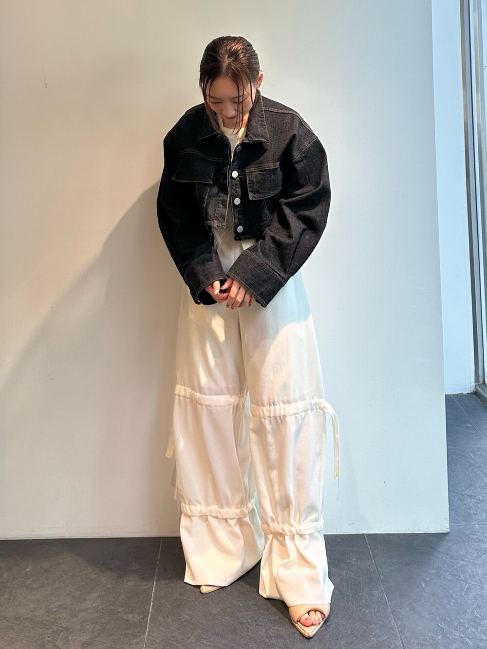 ホワイト系のニット/セーター、ブラック系のデニムジャケット、ホワイト系のその他パンツを着用したレディースの夏コーディネートの2枚目の写真