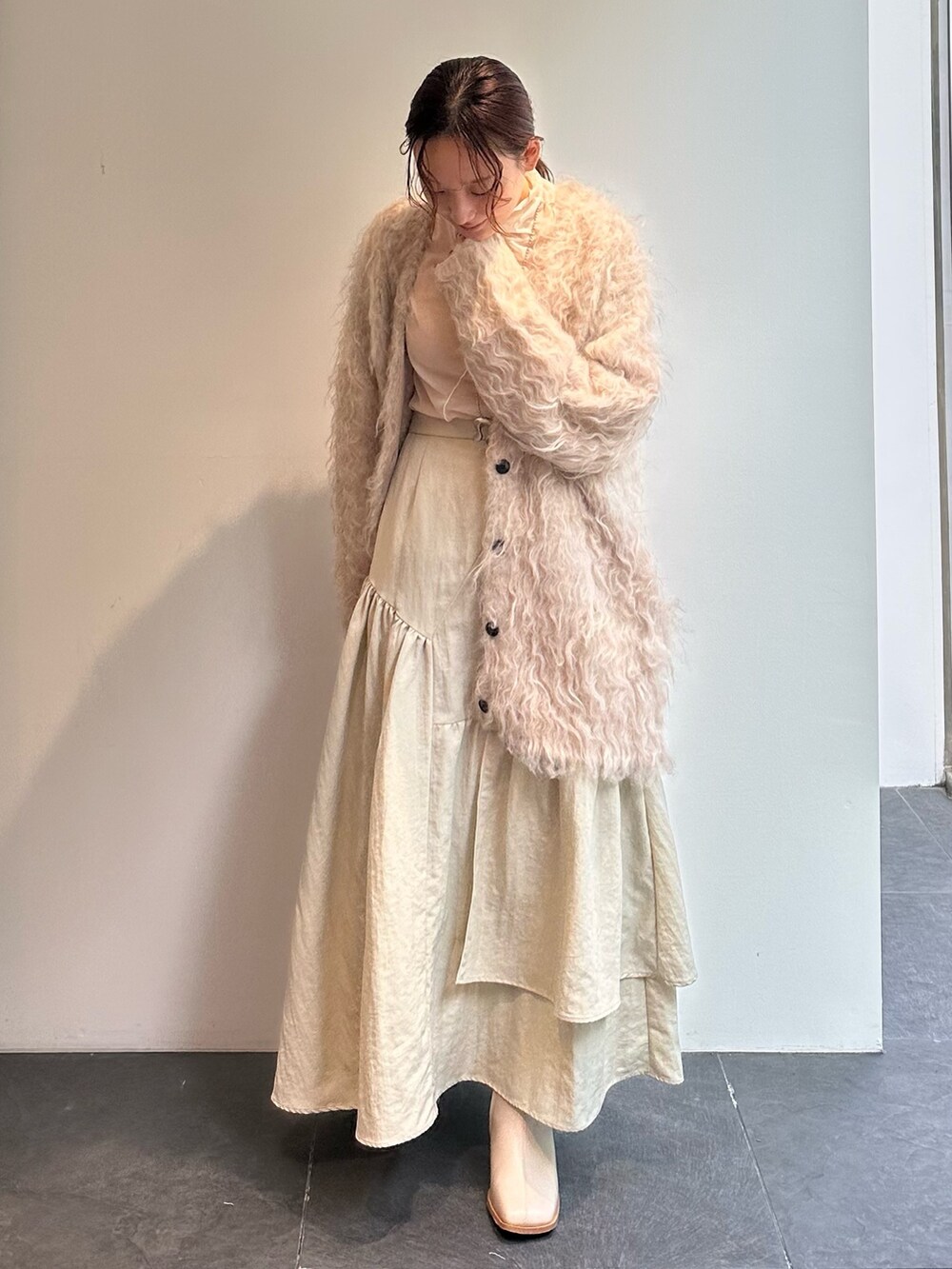 ホワイト系のTシャツ/カットソー、ベージュ系のスカート、ベージュ系のカーディガン/ボレロを着用したレディースの秋コーディネートの3枚目の写真