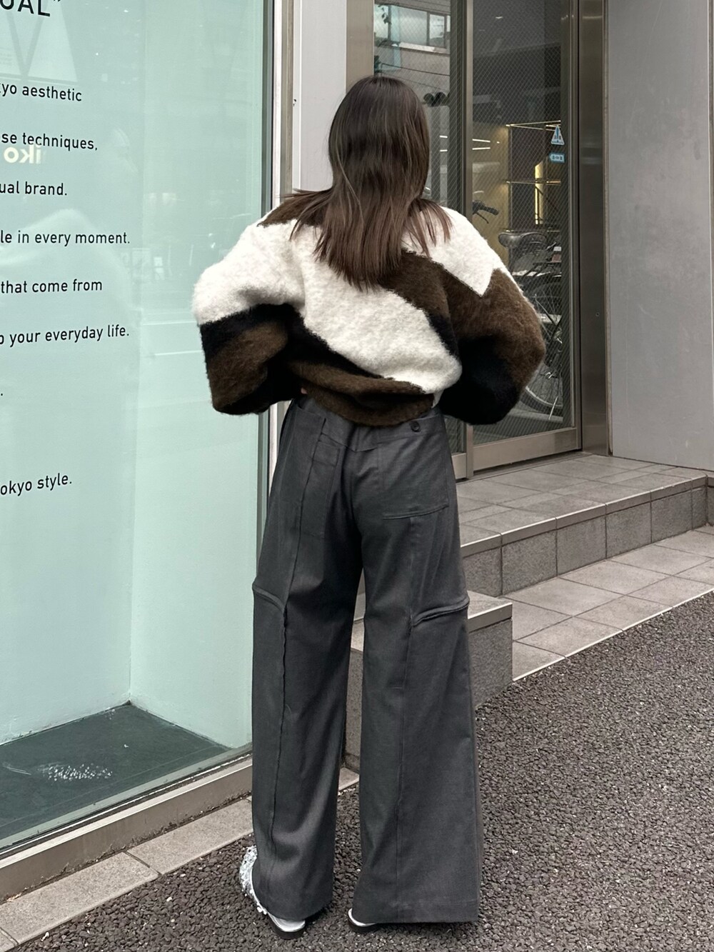 グレー系のスラックス、グリーン系のニット/セーターを着用したレディースの秋コーディネートの4枚目の写真