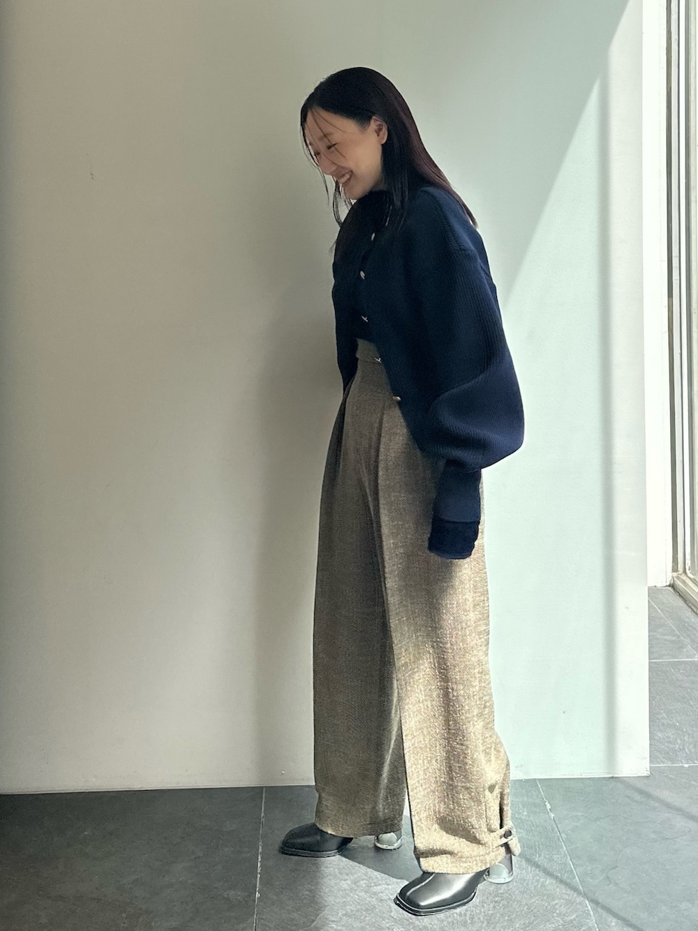 ブラウン系のスラックス、ブルー系のカーディガン/ボレロ、ブルー系のTシャツ/カットソーを着用したレディースの秋コーディネートの3枚目の写真