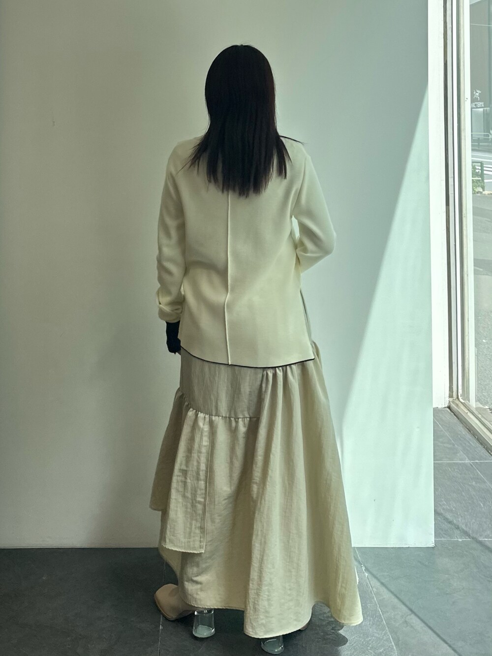 ブラック系のTシャツ/カットソー、ベージュ系のニット/セーター、ベージュ系のスカートを着用したレディースの秋コーディネートの5枚目の写真