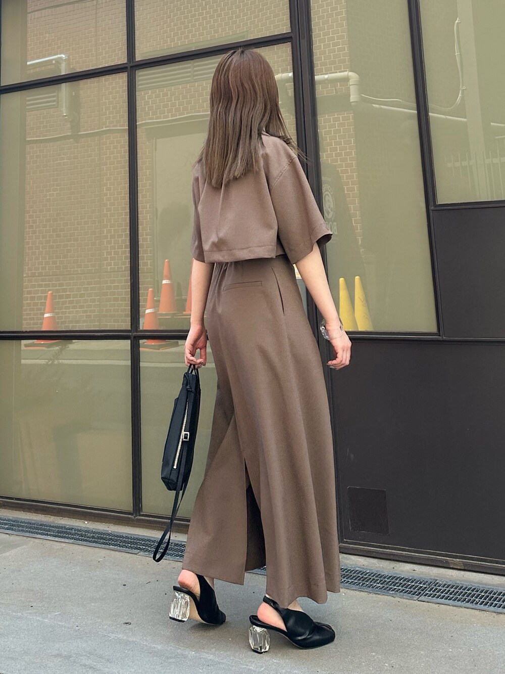 ベージュ系のシャツ/ブラウス、ベージュ系のスカート、ブラック系のハンドバッグを着用したレディースの春コーディネートの5枚目の写真