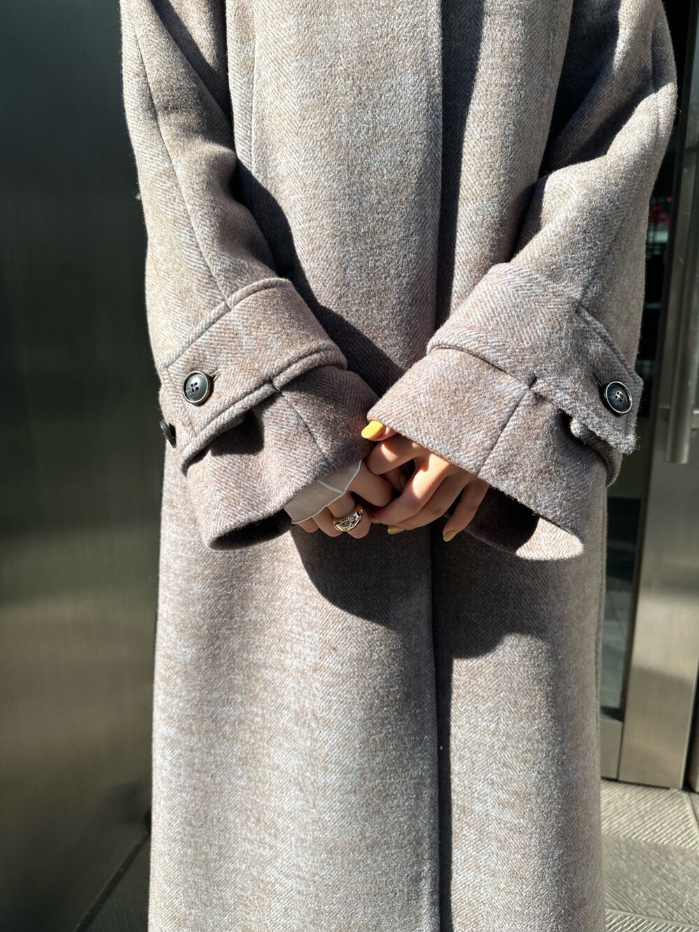 ブルー系のステンカラーコートを着用したレディースの冬コーディネートの4枚目の写真