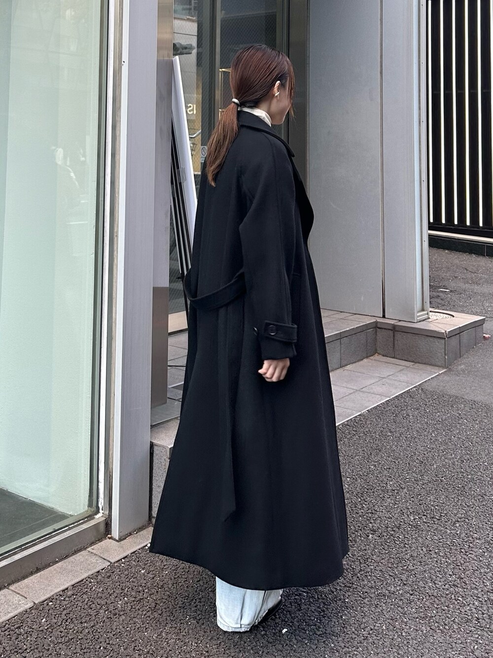 ブラック系のチェスターコートを着用したレディースの秋コーディネートの4枚目の写真