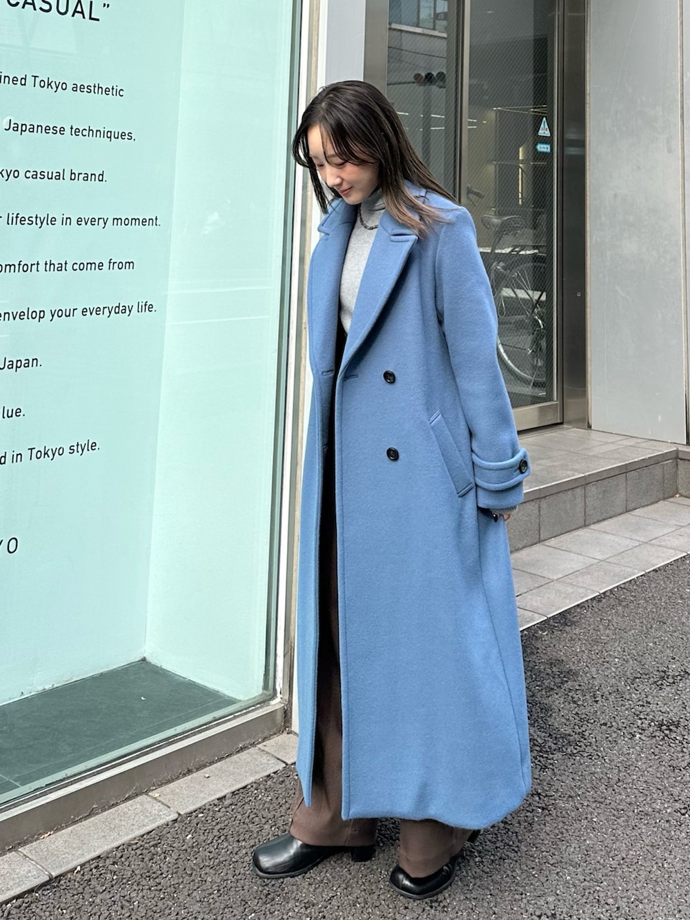 ブルー系のチェスターコートを着用したレディースの秋コーディネートの3枚目の写真