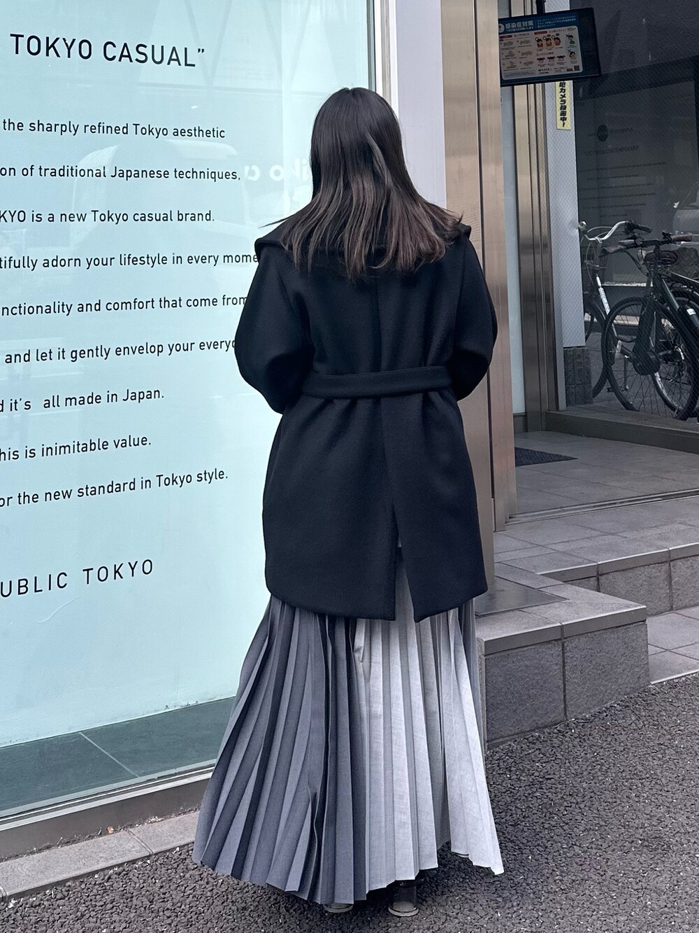 ブラック系のチェスターコート、グレー系のスカートを着用したレディースの冬コーディネートの5枚目の写真