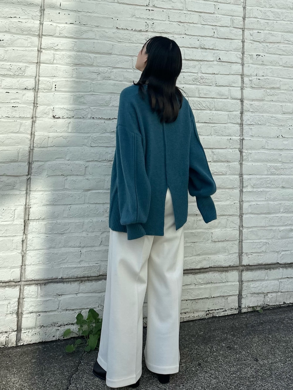 ベージュ系のスラックス、ブルー系のニット/セーターを着用したレディースの秋コーディネートの4枚目の写真