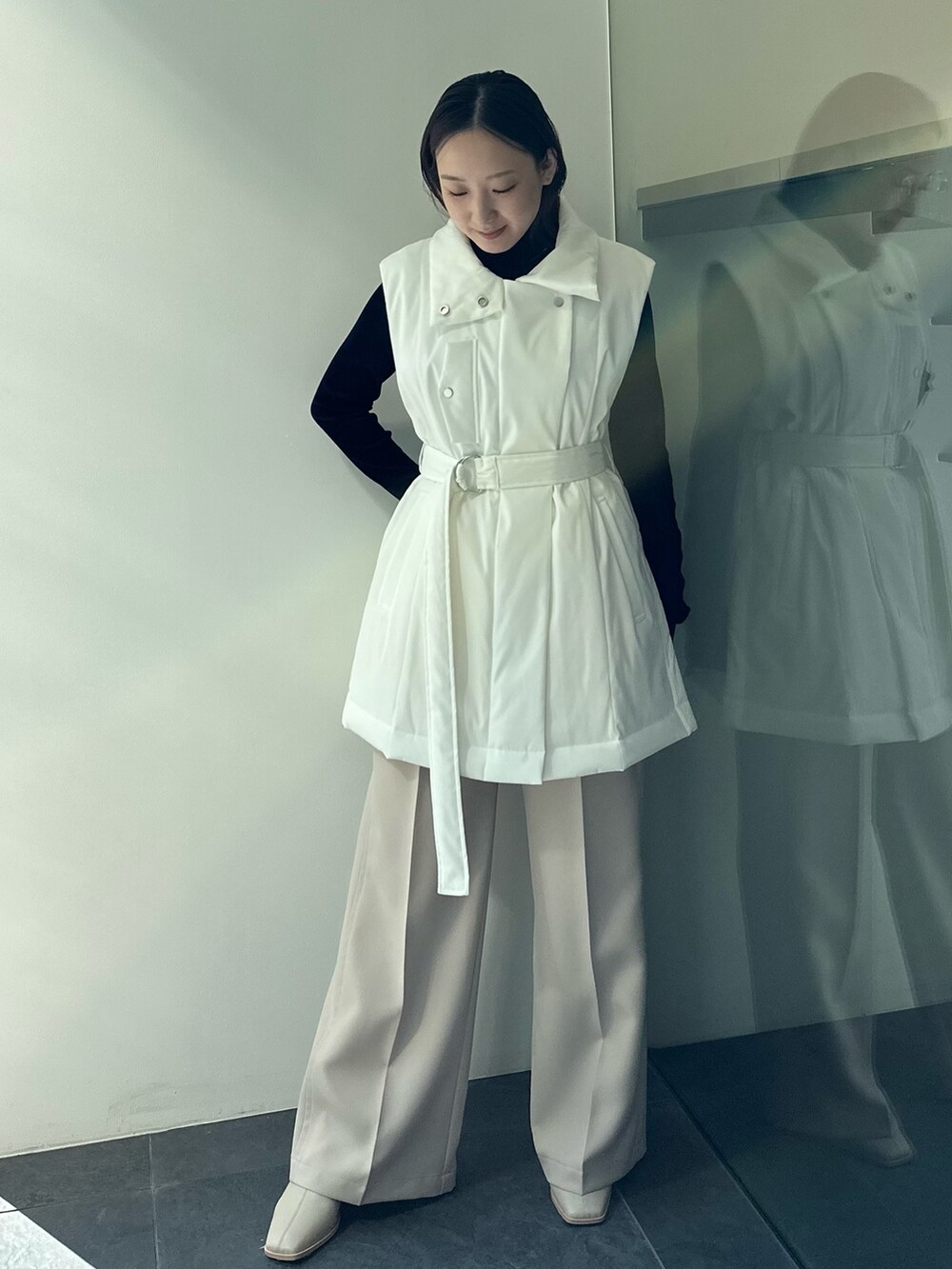 ベージュ系のダウンベスト、ブラック系のTシャツ/カットソー、ベージュ系のその他パンツを着用したレディースの秋コーディネートの2枚目の写真