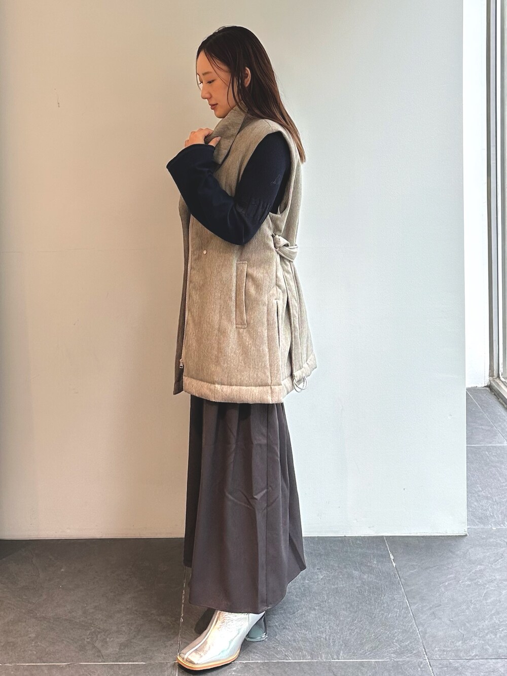 その他のダウンベスト、ブルー系のワンピースを着用したレディースの秋コーディネートの4枚目の写真