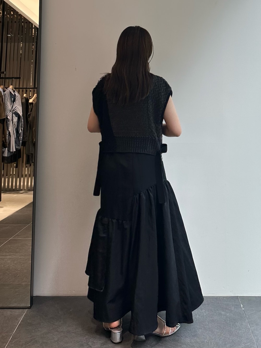 ブラック系のスカート、ブラウン系のベストを着用したレディースの秋コーディネートの6枚目の写真