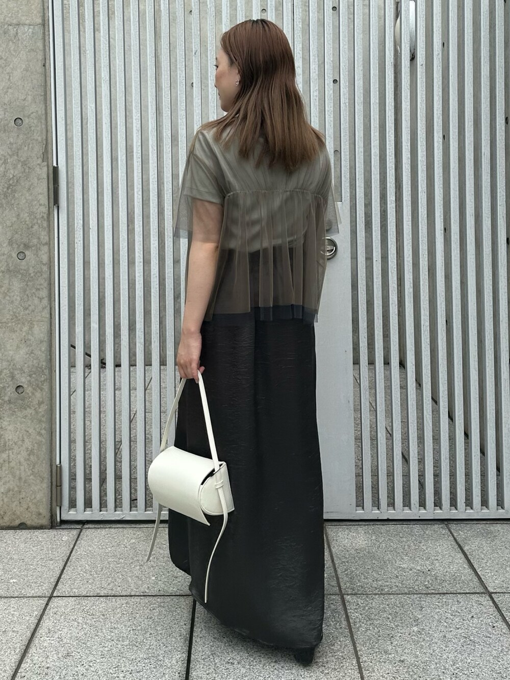 ブラック系のスカート、ベージュ系のシャツ/ブラウス、グリーン系のTシャツ/カットソーを着用したレディースの夏コーディネートの5枚目の写真