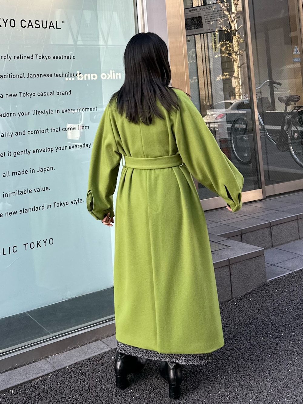 グリーン系のノーカラーコートを着用したレディースの冬コーディネートの4枚目の写真