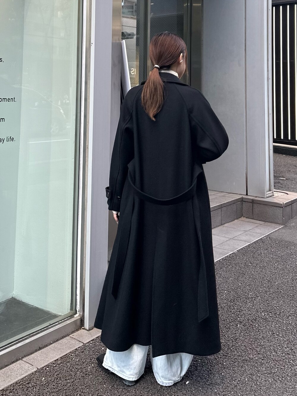 ブラック系のチェスターコートを着用したレディースの秋コーディネートの3枚目の写真