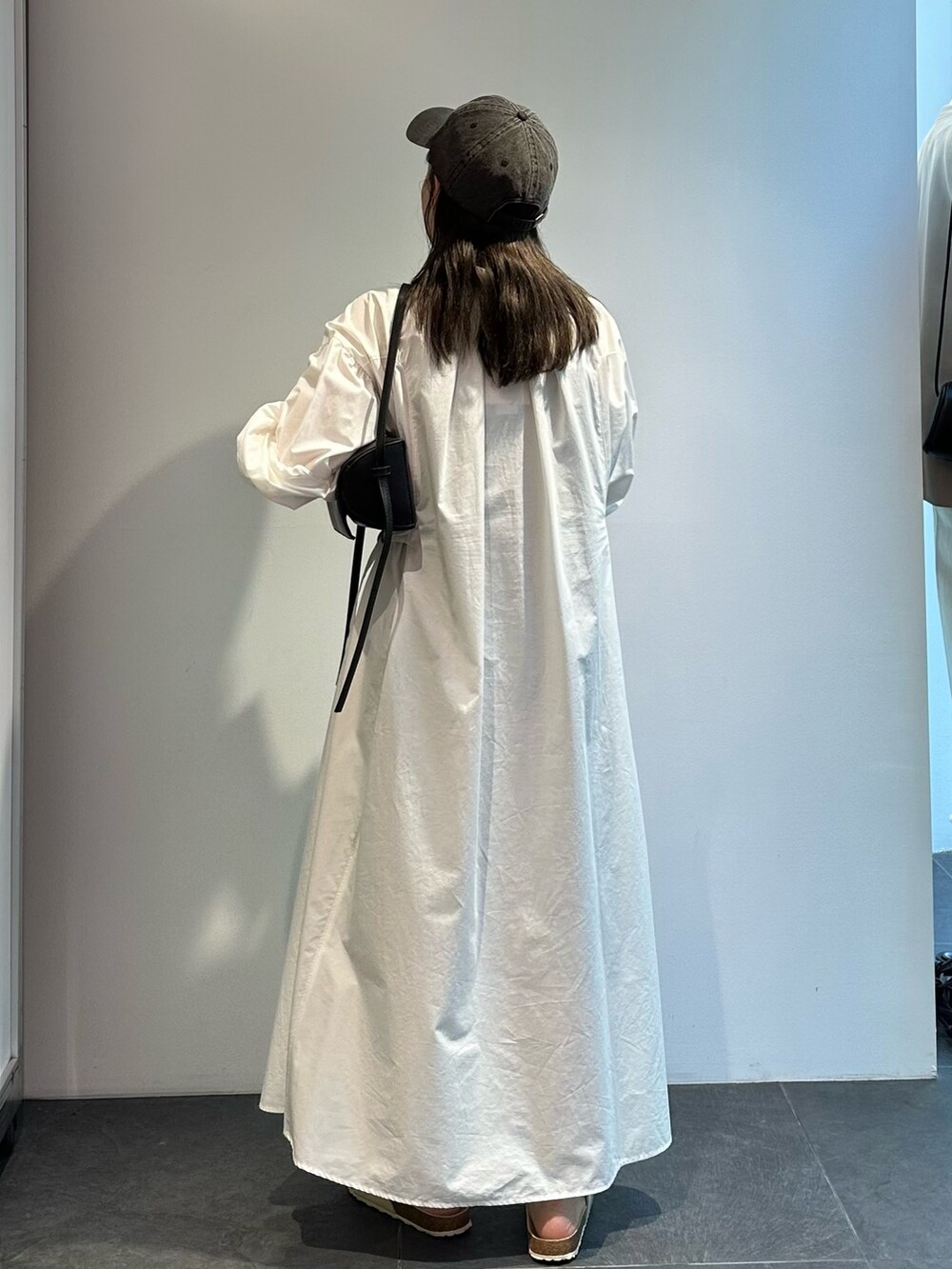 ホワイト系のシャツワンピースを着用したレディースの夏コーディネートの3枚目の写真