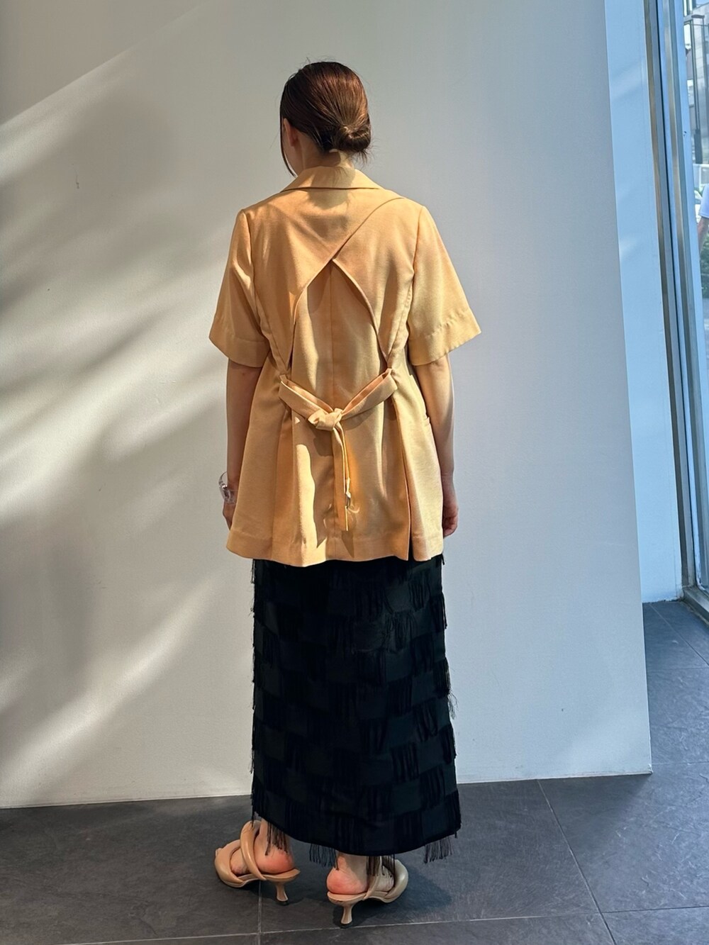 オレンジ系のシャツ/ブラウス、ブラック系のスカートを着用したレディースの夏コーディネートの5枚目の写真