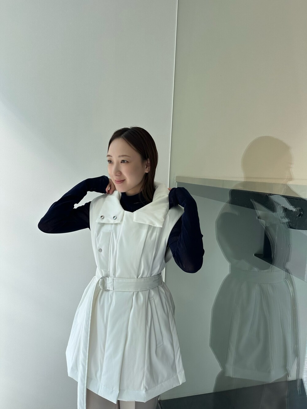 ベージュ系のダウンベスト、ブラック系のTシャツ/カットソー、ベージュ系のその他パンツを着用したレディースの秋コーディネートの6枚目の写真