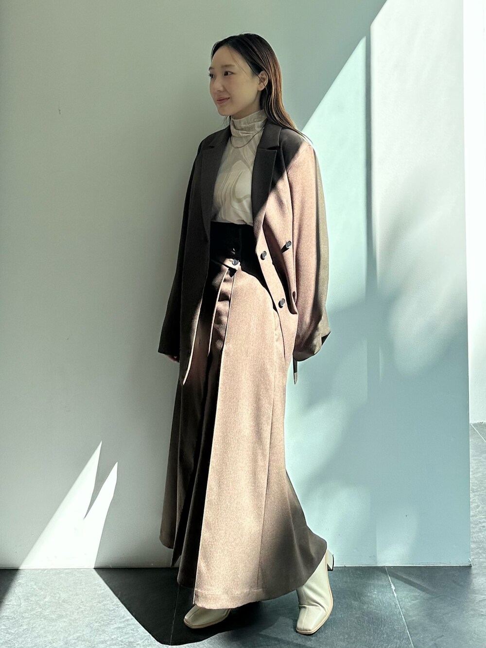 ブラウン系のテーラードジャケット、ブラウン系のスカートを着用したレディースの秋コーディネートの2枚目の写真