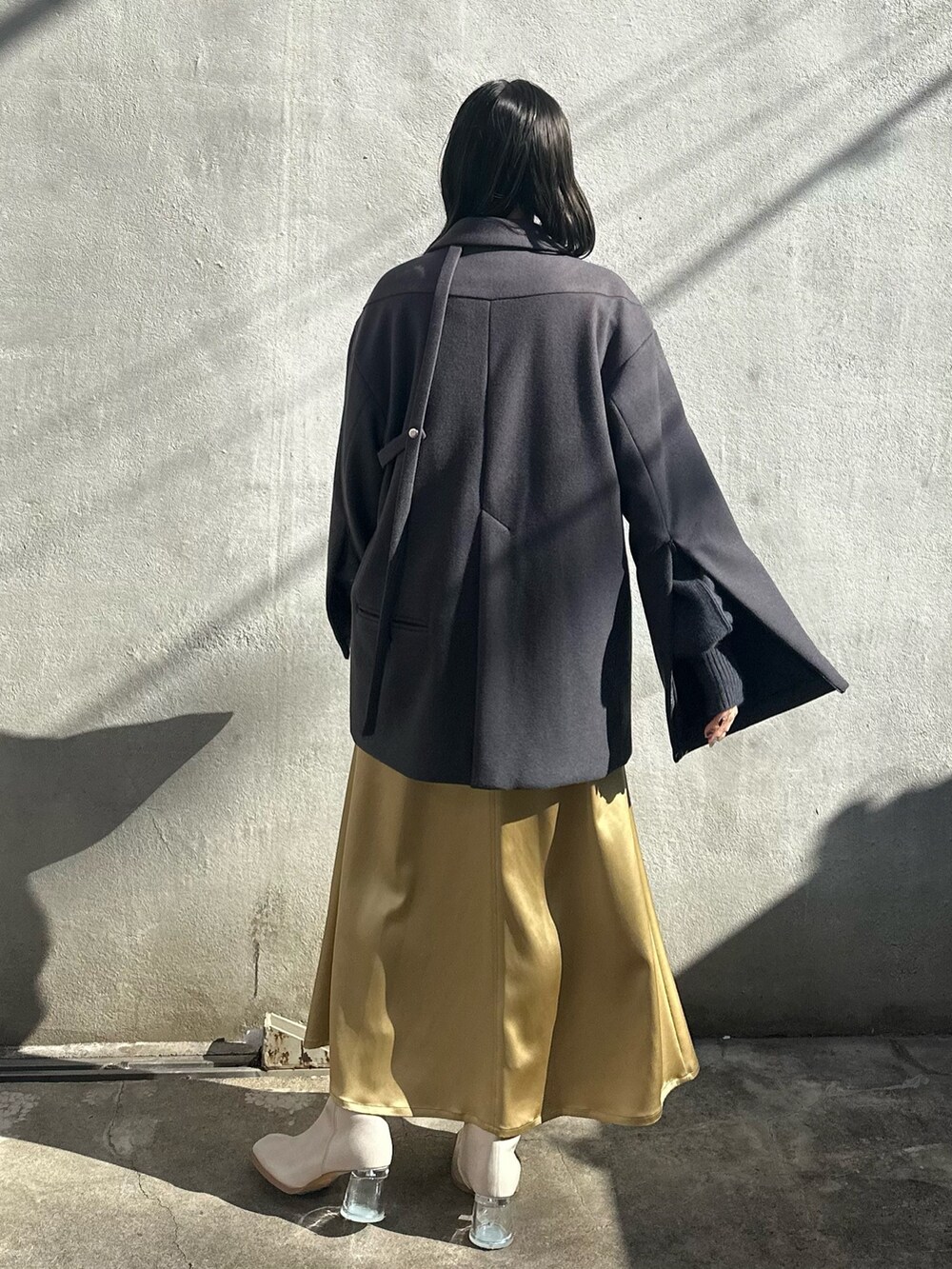 イエロー系のスカート、グレー系のニット/セーター、グレー系のテーラードジャケットを着用したレディースの秋コーディネートの3枚目の写真