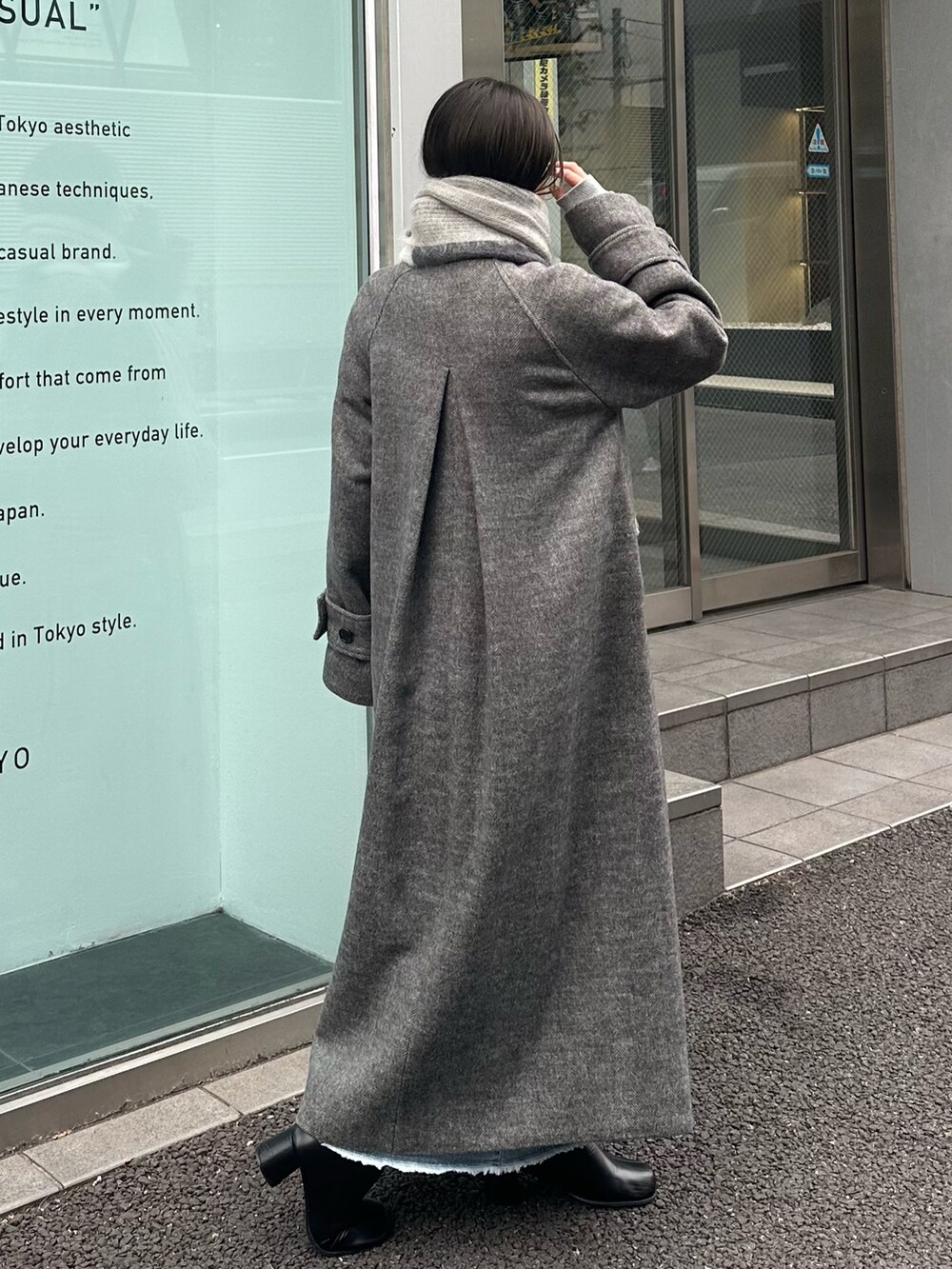 ブルー系のステンカラーコート、グレー系のマフラーを着用したレディースの冬コーディネートの4枚目の写真