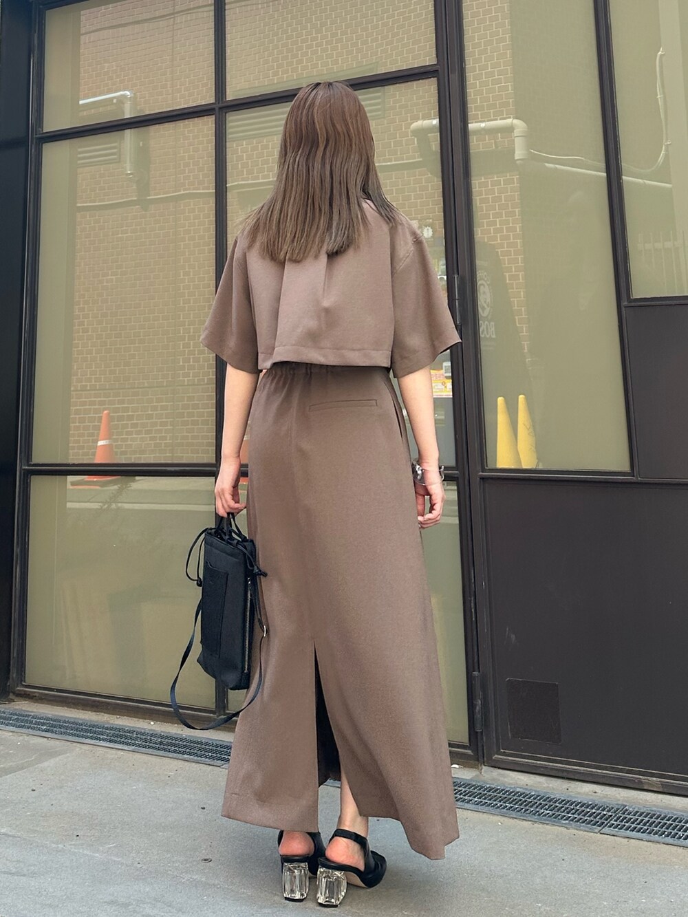 ベージュ系のシャツ/ブラウス、ベージュ系のスカート、ブラック系のハンドバッグを着用したレディースの春コーディネートの6枚目の写真