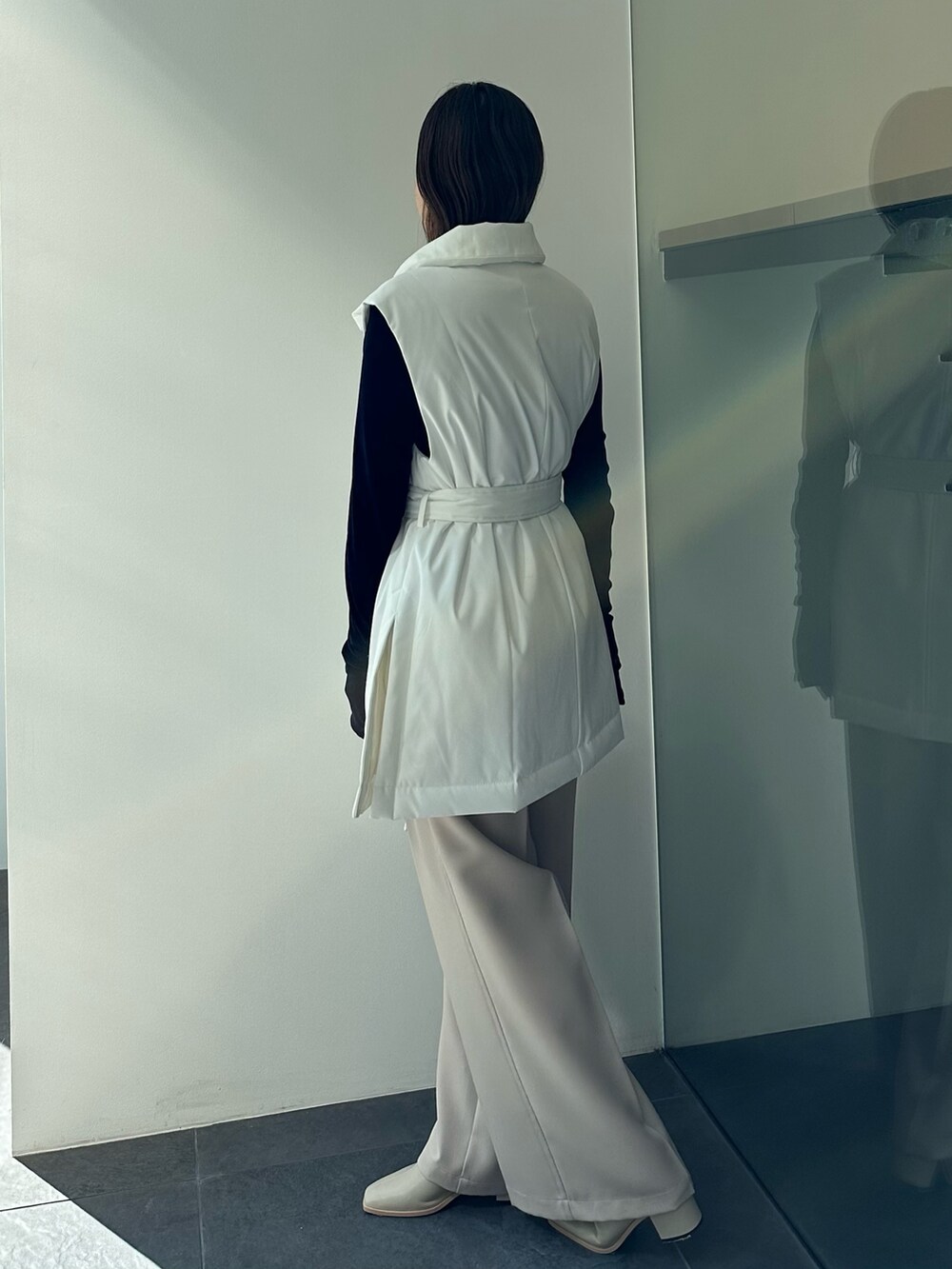 ベージュ系のダウンベスト、ブラック系のTシャツ/カットソー、ベージュ系のその他パンツを着用したレディースの秋コーディネートの4枚目の写真