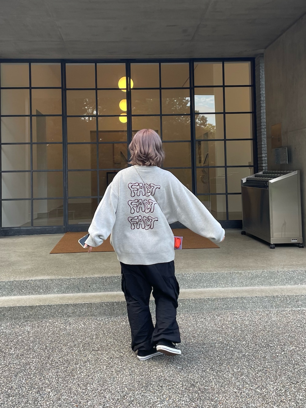 ブラック系のカーゴパンツ、グレー系のニット/セーター、オレンジ系のショルダーバッグを着用したレディースの秋コーディネートの2枚目の写真