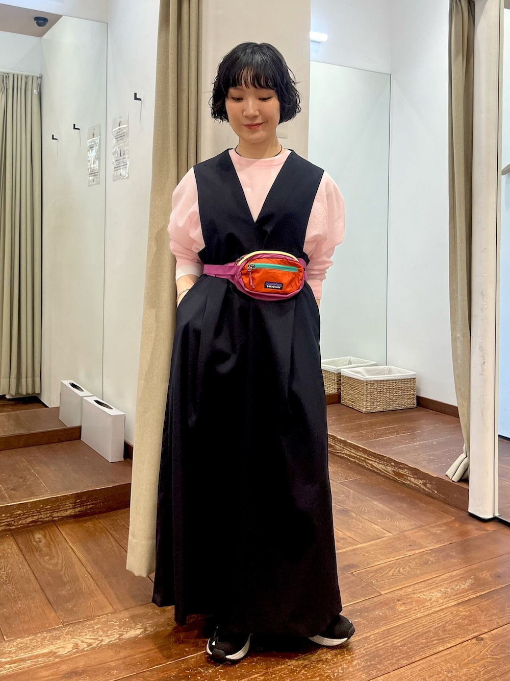 ブラック系のスニーカー、ブルー系のワンピース、ピンク系のニット/セーターを着用したレディースの冬コーディネートの2枚目の写真