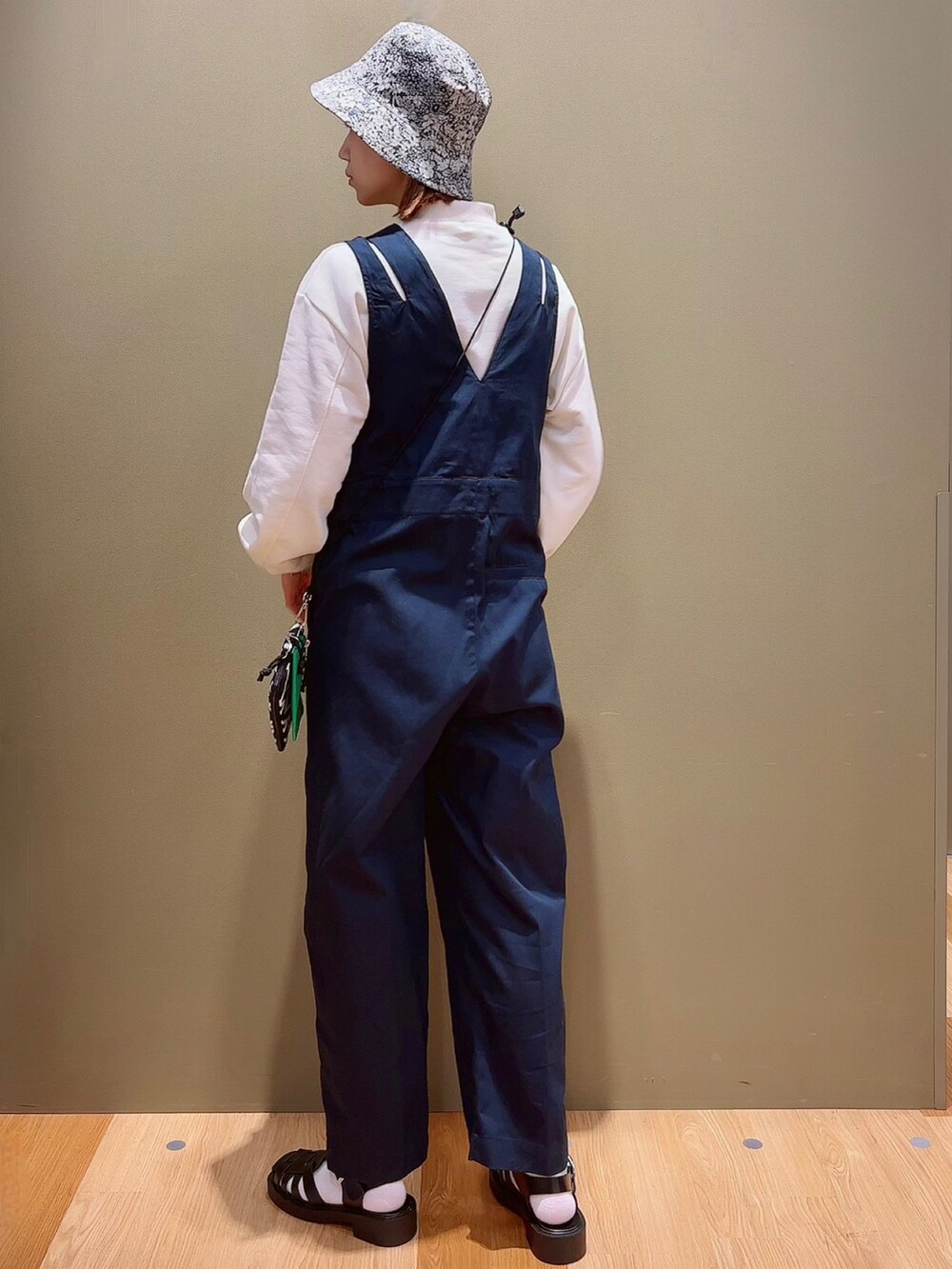 ホワイト系のスウェット、ブルー系のつなぎ/オールインワン、ブラック系のサンダルを着用したレディースの春コーディネートの4枚目の写真