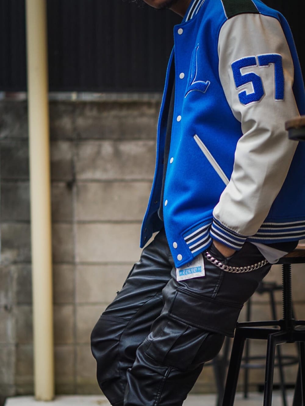 ブルー系のスタジャン、ブラック系のカーゴパンツ、ブラック系のスニーカーを着用したメンズの冬コーディネートの2枚目の写真