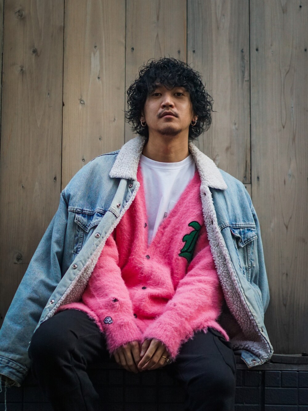 ブルー系のデニムジャケット、ピンク系のカーディガン/ボレロ、ブラック系のカーゴパンツを着用したメンズの冬コーディネートの2枚目の写真