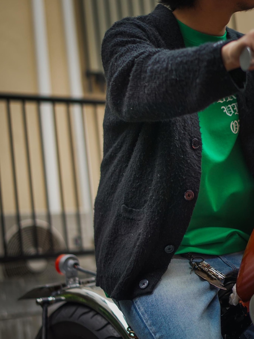 グリーン系のTシャツ/カットソー、ブラック系のカーディガン/ボレロ、ブルー系のデニムパンツを着用したメンズの春コーディネートの2枚目の写真