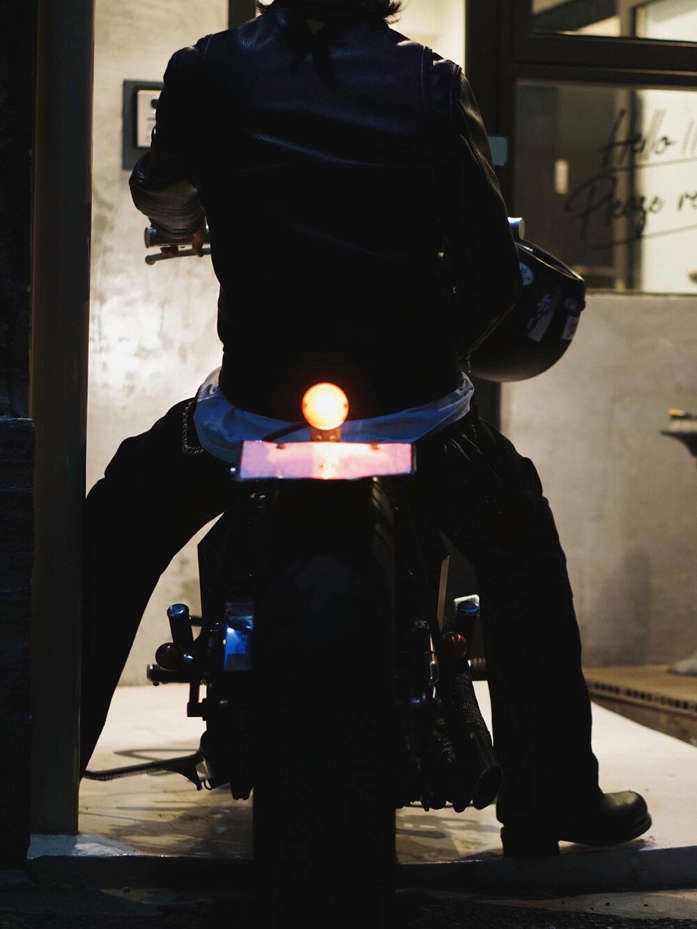 ブラック系のライダースジャケット、ブラック系のカーゴパンツ、ピンク系のサングラスを着用したメンズの春コーディネートの3枚目の写真