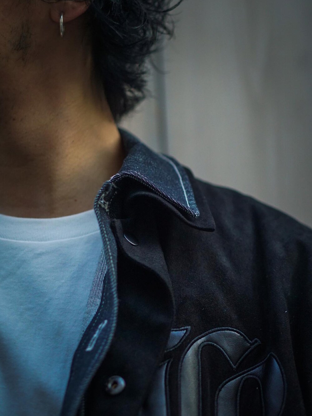 ブラック系のジャケット/アウター、ブルー系のデニムパンツを着用したメンズの冬コーディネートの4枚目の写真