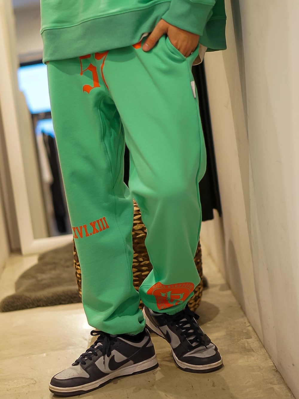 グリーン系のパーカー、グリーン系のスウェットパンツ、グレー系のスニーカーを着用したメンズの冬コーディネートの3枚目の写真