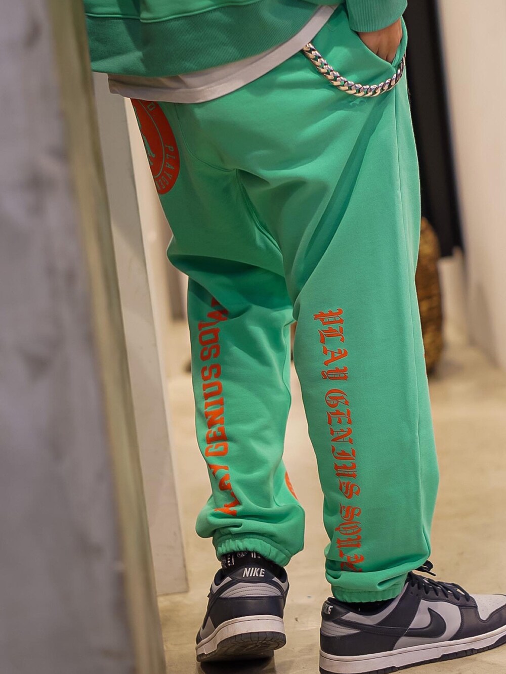 グリーン系のパーカー、グリーン系のスウェットパンツ、グレー系のスニーカーを着用したメンズの冬コーディネートの4枚目の写真