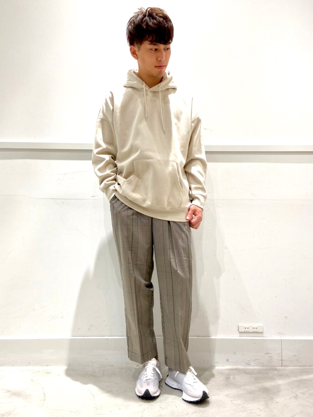 ベージュ系のスラックス、グレー系のスニーカー、グリーン系のモッズコートを着用したメンズの秋コーディネートの2枚目の写真